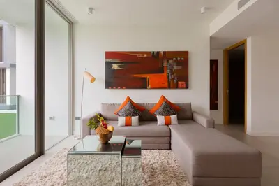 a living room with a couch and a glass table at Oceanstone by Holy Cow, 2-BR, 90 m2, pool view in Bang Tao Beach
