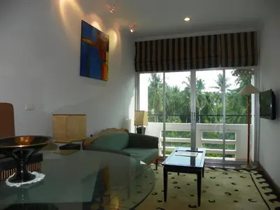 a living room with a couch and a glass table at Orchid Kathu Heights Service Apartments in Kathu