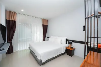 a bedroom with a white bed and a window at The One Cozy, Phuket in Chalong