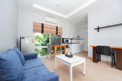 a living room with a blue couch and a table at The One Cozy, Phuket in Chalong