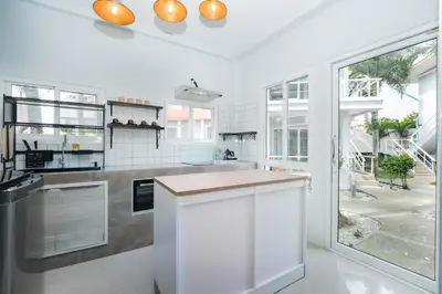 a kitchen with white walls and a large window at The One Cozy, Phuket in Chalong