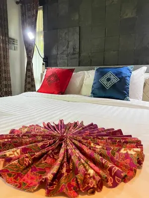 a bed with a colorful blanket on top of it at Bangtao Beach Chalet Resort in Bang Tao Beach