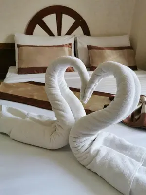 two swans made out of towels sitting on a bed at Natacha Hotel in Phi Phi Don