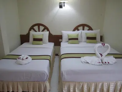 two beds in a room with swans on them at Natacha Hotel in Phi Phi Don
