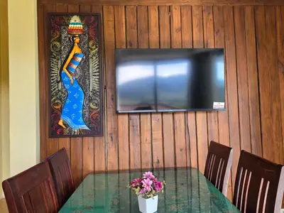 a table with a television and a vase of flowers at Krabi Green Hill Pool Villas in Ban Nong Thale