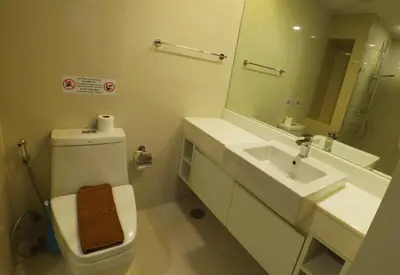a bathroom with a toilet and a sink and a mirror at 1-BR Sea View, Aristo condo, Surin Beach in Surin Beach
