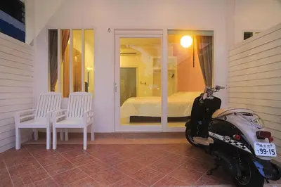 a motor scooter parked in a room with a bedroom at Clear House Phuket in Kamala Beach