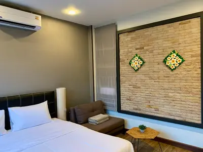 a bedroom with a bed and a brick wall at Baan Fran Sim Da in Bang Tao Beach
