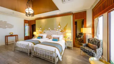 a bedroom with two beds and a chandelier at Maikhao Dream Villa Resort and Spa, Maikhao Phuket in Mai Khao Beach