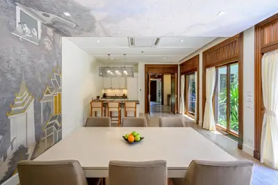 a dining room with a white table and chairs at Maikhao Dream Villa Resort and Spa, Maikhao Phuket in Mai Khao Beach