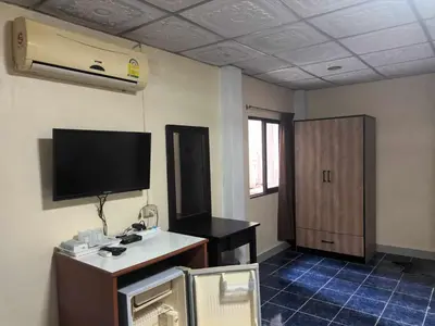 a room with a tv and a desk in a room at Patong Rose Guest House 50m to Beach in Patong Beach