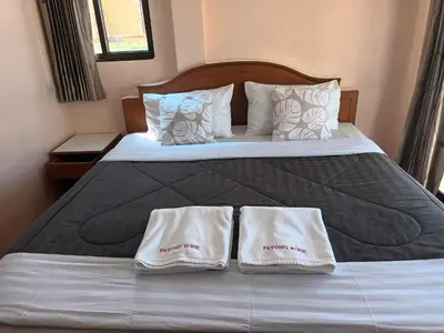 a bedroom with a bed with two towels on it at Patong Rose Guest House 50m to Beach in Patong Beach