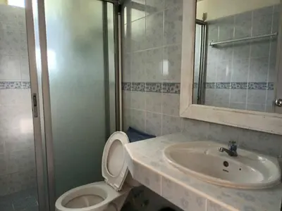 a bathroom with a sink and a toilet and a mirror at Patong Rose Guest House 50m to Beach in Patong Beach