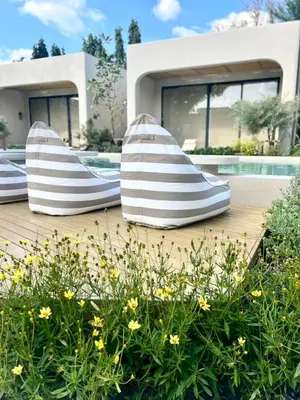 two pillows sitting on a deck in front of a house at Eden Resort & Villas Phuket Patong in Patong Beach