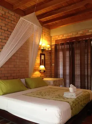 a bedroom with a bed with a mosquito net at Sea Pines & Liberg in Nai Yang Beach