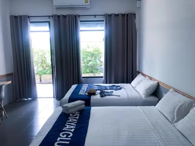 a bedroom with two beds and a window at Glur Phuket Patong Beach in Patong Beach