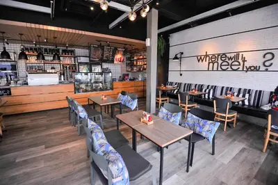 a restaurant with tables and chairs and a counter at Glur Phuket Patong Beach in Patong Beach