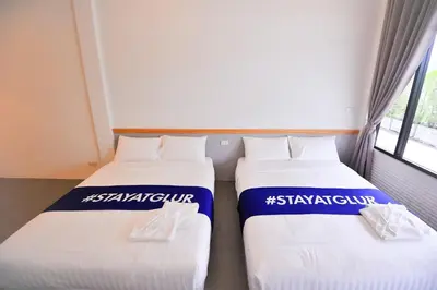 two beds sitting next to each other in a room at Glur Phuket Patong Beach in Patong Beach