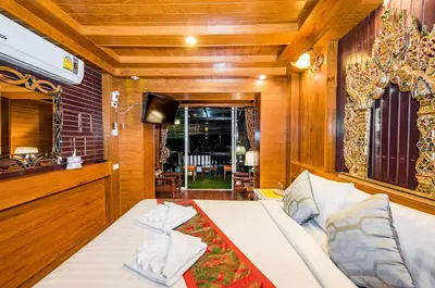 a bedroom with a bed and a tv in a room at Baan Ratchapruek in Phuket Town