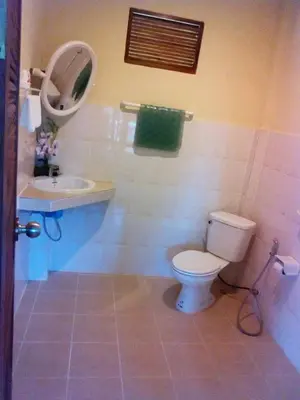 a bathroom with a toilet and a sink and a mirror at Mookdaman Bungalow in Ko Yao Noi