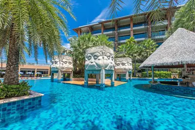 a swimming pool with two chairs in a resort at Rawai Palm Beach Resort - SHA Extra Plus in Rawai Beach