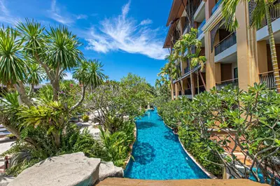 a resort corridor with a blue waterway in front of a building at Rawai Palm Beach Resort - SHA Extra Plus in Rawai Beach