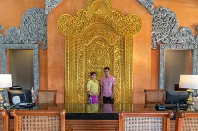 a man and a woman standing in front of a gold gate at Rawai Palm Beach Resort - SHA Extra Plus in Rawai Beach