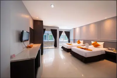a hotel room with two beds and a television at FunDee Boutique Hotel in Patong Beach