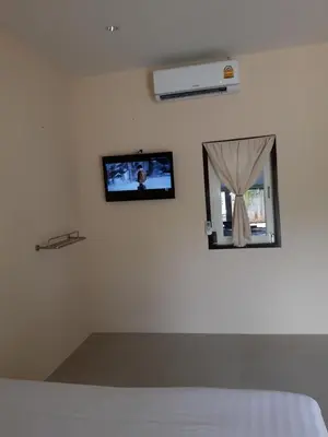 a bedroom with a tv on the wall and a window at Classic home in Bang Tao Beach