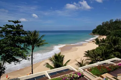 a view of the beach from the balcony of a resort at Andaman White Beach Resort - SHA Plus in Nai Thon Beach