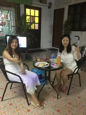 two girls in white sitting around a table at Hero Phuket in Nai Yang Beach
