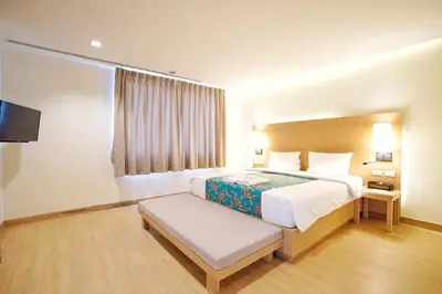 a hotel room with a bed and a tv at Baan Suwantawe in Phuket Town