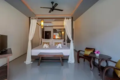a bedroom with a bed and a ceiling fan at Phuketa Hotel Phuket Town in Phuket Town