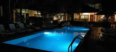 a large swimming pool at night with blue lights at Happy Cottage in Chalong