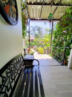 a bench in a room with a clock on the wall at Happy Cottage in Chalong
