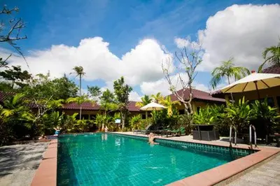 a swimming pool in front of a resort at Happy Cottage in Chalong