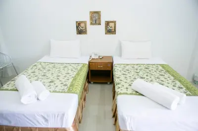 a room with two beds and a dresser in it at G&B Guesthouse in Patong Beach