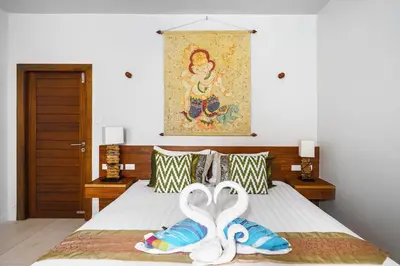 a bedroom with a bed with two swans on it at Nenuphar Villa by G Estate in Rawai Beach