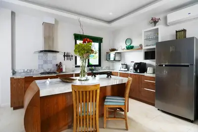 a kitchen with a center island with a vase of flowers at Nenuphar Villa by G Estate in Rawai Beach