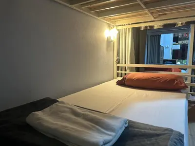 a bedroom with two beds in a room with a window at Hangover Hostel in Phi Phi Don
