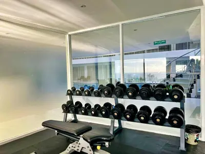 a gym with a bunch of dumbbells on a shelf at Sunset Plaza by RESAVA in Karon Beach