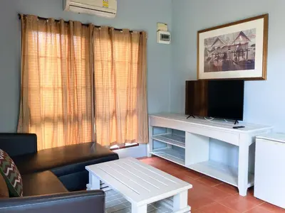 a living room with a couch and a tv at Flora Ville-SHA PLUS in Chalong