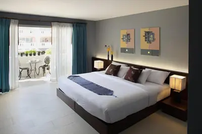 a bedroom with a large bed and a table with chairs at Samkong Place in Phuket Town