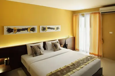 a bedroom with a large white bed with a window at Samkong Place in Phuket Town