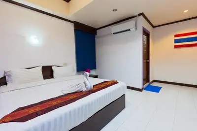 a hotel room with a bed with a towel on it at Grand Orchid Inn Patong beach in Patong Beach