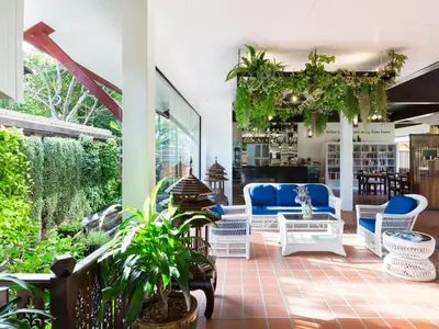 a patio with blue and white furniture and plants at Le Piman Resort in Rawai Beach