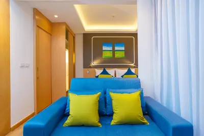 a blue couch with yellow pillows in a room at The Aristo Beach by Holy Cow, studio, without kitchen, construction view in Surin Beach