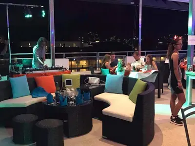 a group of people sitting at tables on a balcony at Grand Sunset Hotel Phuket in Karon Beach