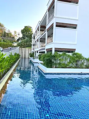 a swimming pool in front of a building at Bel Air Cape Panwa Resort Phuket in Panwa Beach