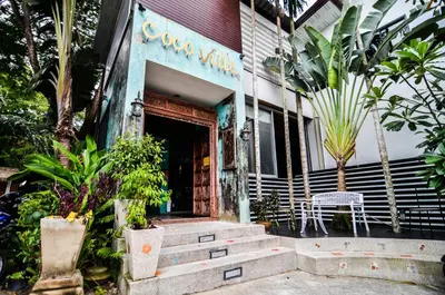 a building with a chair and stairs in front of it at Cocoville Phuket - SHA Plus in Chalong